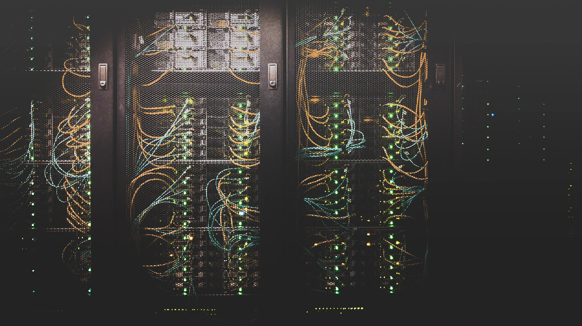 Corredor de data center com racks iluminados por luz âmbar ao fundo